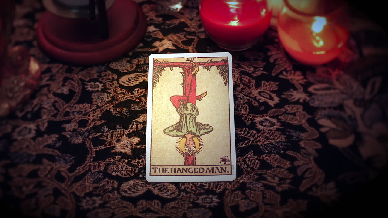 un adivino místico selecciona una carta del tarot y la coloca en la mesa encantada