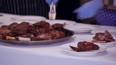 waiter serving meat at restaurant. close up of waiter serving food on plates in restaurant