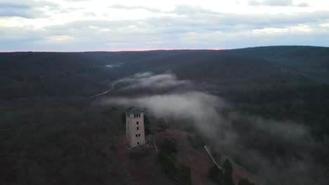 medieval castle watchtower in mystical foggy landscape, aerial