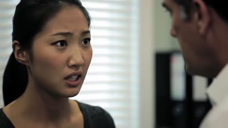 tension fills the air as a woman confronts a man in an office environment. she gestures animatedly while expressing her frustrations.