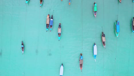 Botes-De-Cola-Larga-Con-Vista-De-Arriba-Hacia-Abajo-Sobre-Aguas-Turquesas-A-Lo-Largo-De-La-Playa-Y-Cabañas-De-Madera-En-Tailandia