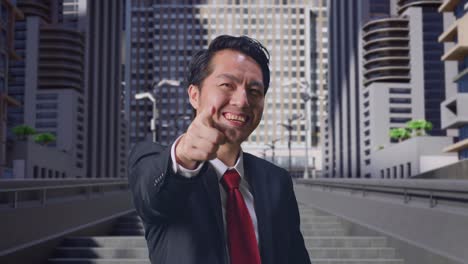 an asian business man smiling and making honest gesture in city