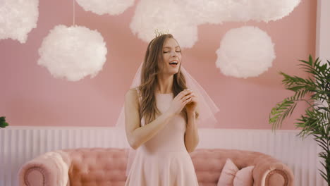 Front-View-Of-A-Happy-Bachelor-Girl-With-Headdress-And-Veil-Showing-Her-Engagement-Ring-To-The-Camera