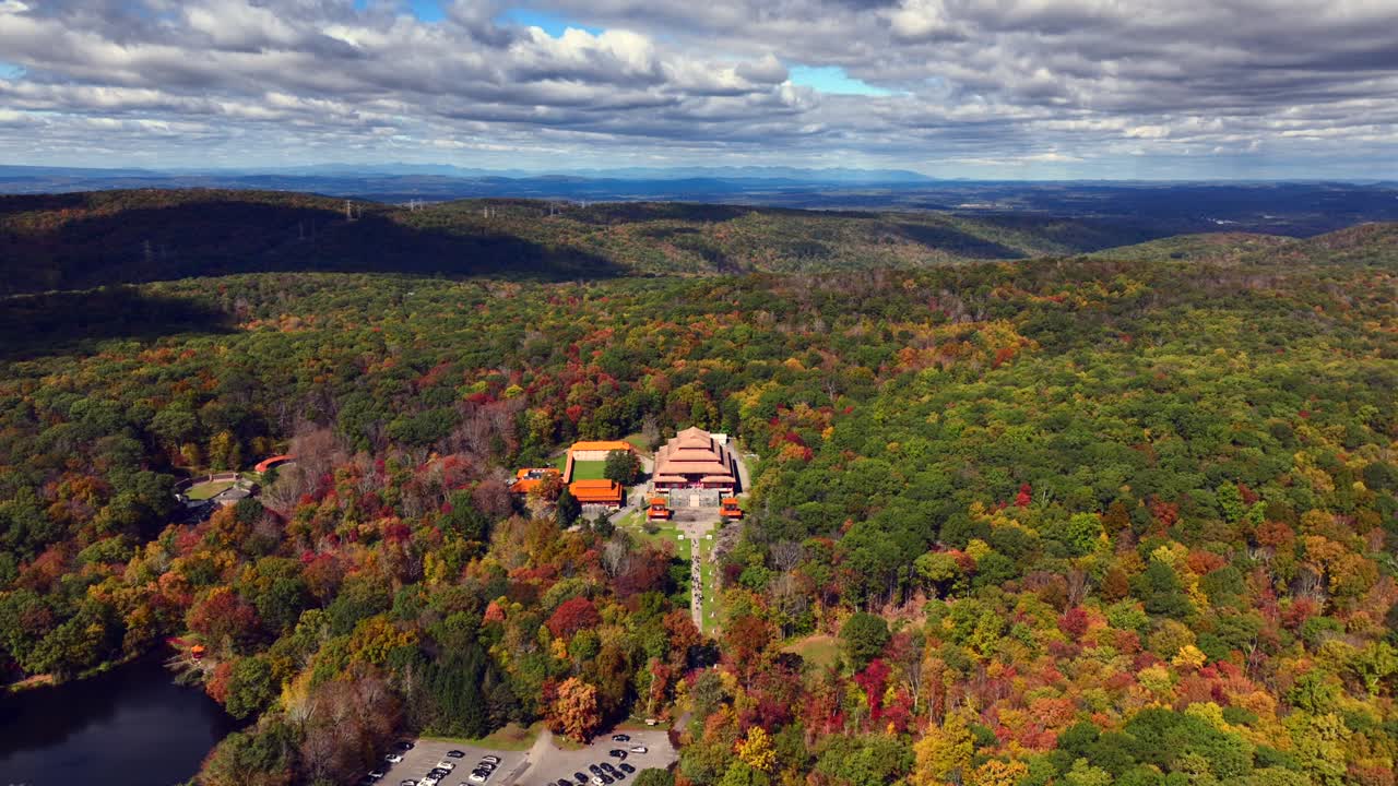 una vista aérea del monasterio de chuang yen en un día soleado, las hojas de los árboles comienzan a cambiar para el otoño