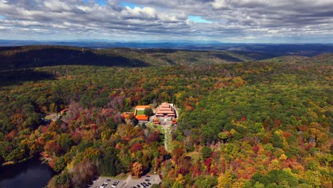An-aerial-view-of-the-Chuang-Yen-Monastery-on-a-sunny-day,-the-leaves-of-the-trees-begin-to-change-for-autumn