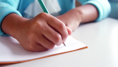 mid-section of school kid doing homework in classroom at school