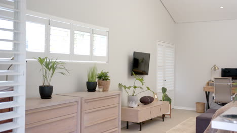modern living room with indoor plants, wall-mounted tv, and wooden furniture, copy space