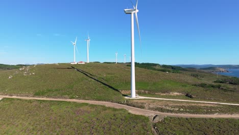 Windmills-In-Scenic-Fields-In-The-Galician-Coast-In-Spain---aerial-drone-shot