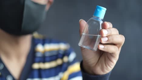 person holding a hand sanitizer bottle