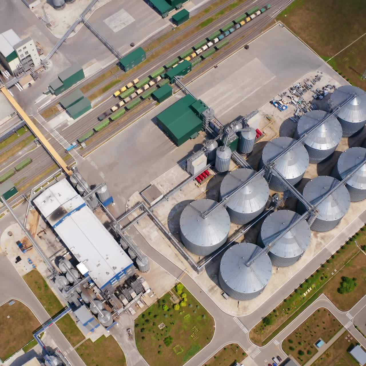 Grain silos on agricultural land. Steel grain elevators. Storage containers for crop. Agriculture Industry. Top aerial view