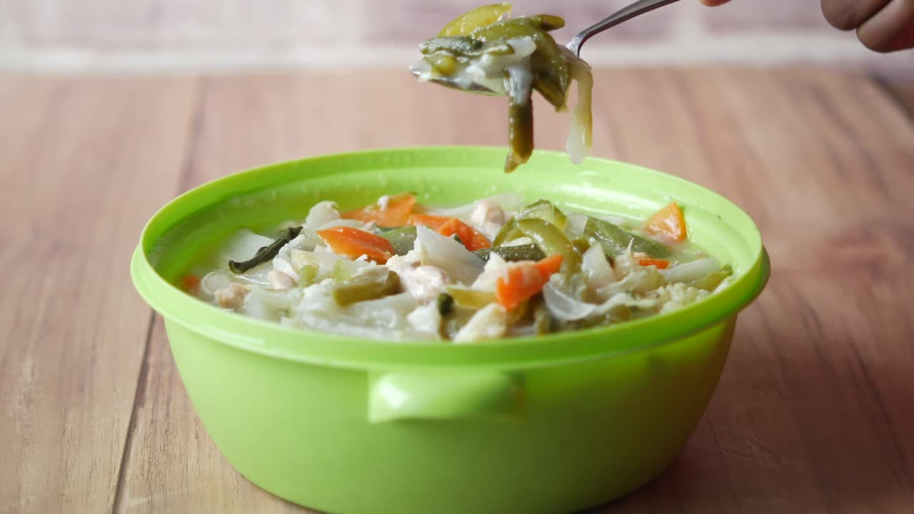 persona que come una sopa saludable