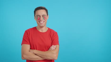 Man standing with portuguese flag painted on face smiling