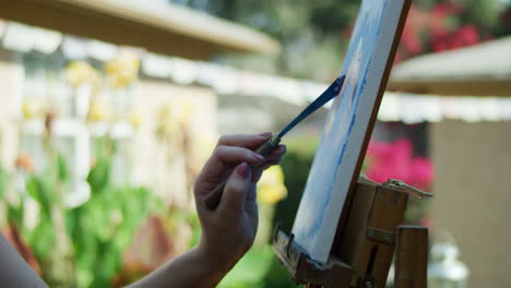 slow motion video of female artist using palette knife on oil painting background blurred camera panning down slowly