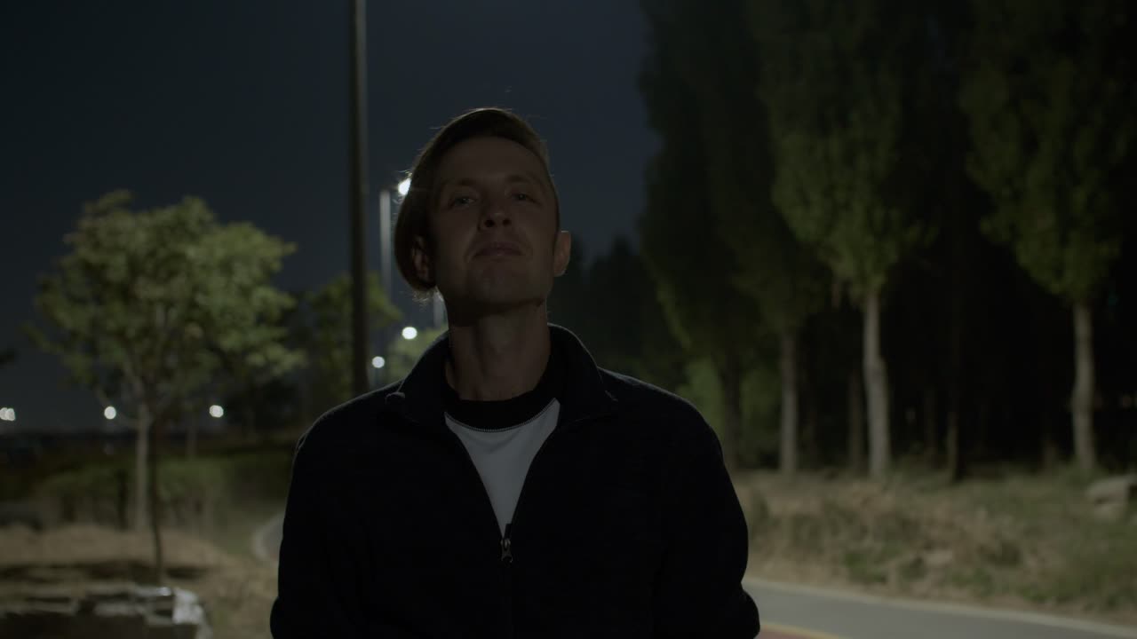 백인 백인 남성 모델은 야간 공원 야외에서 손으로 수업 제스처처럼 좋은 모습을 보여줍니다