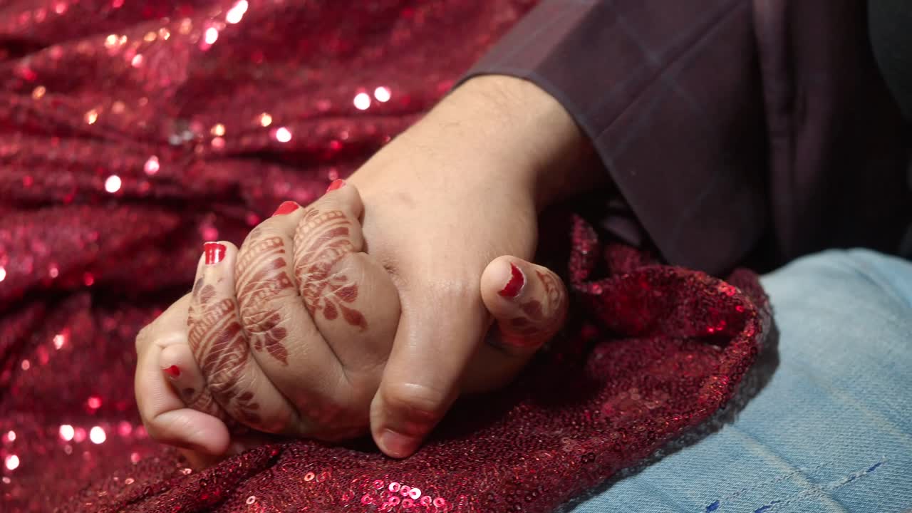 Coppia che si tiene per mano con tatuaggio all'henné