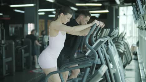 una pareja trabajando en una cinta de correr en un gimnasio
