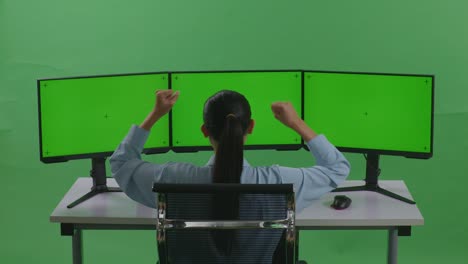 mujer celebrando el éxito en el monitor triple