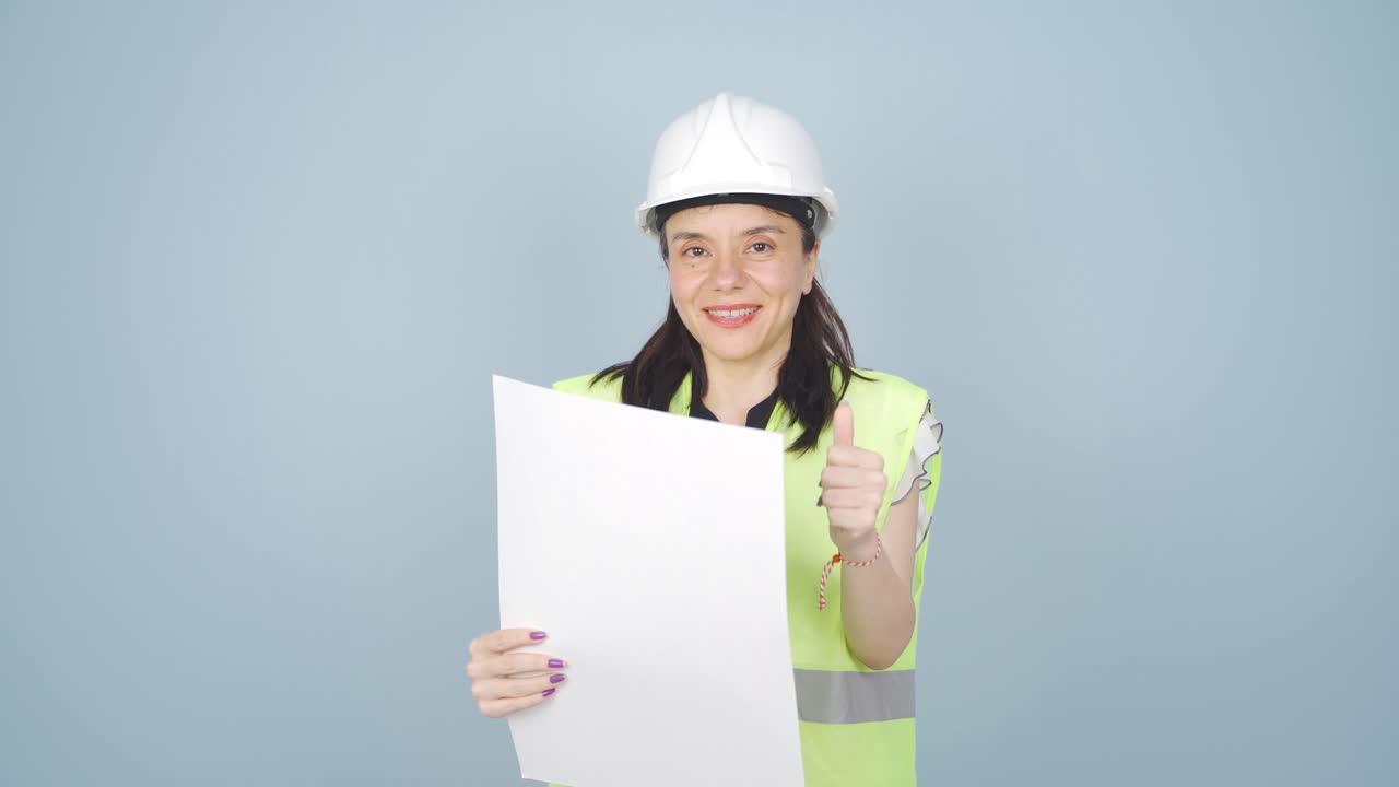 엔지니어는 카메라를 쳐다보고 긍정적인 제스처를 합니다.