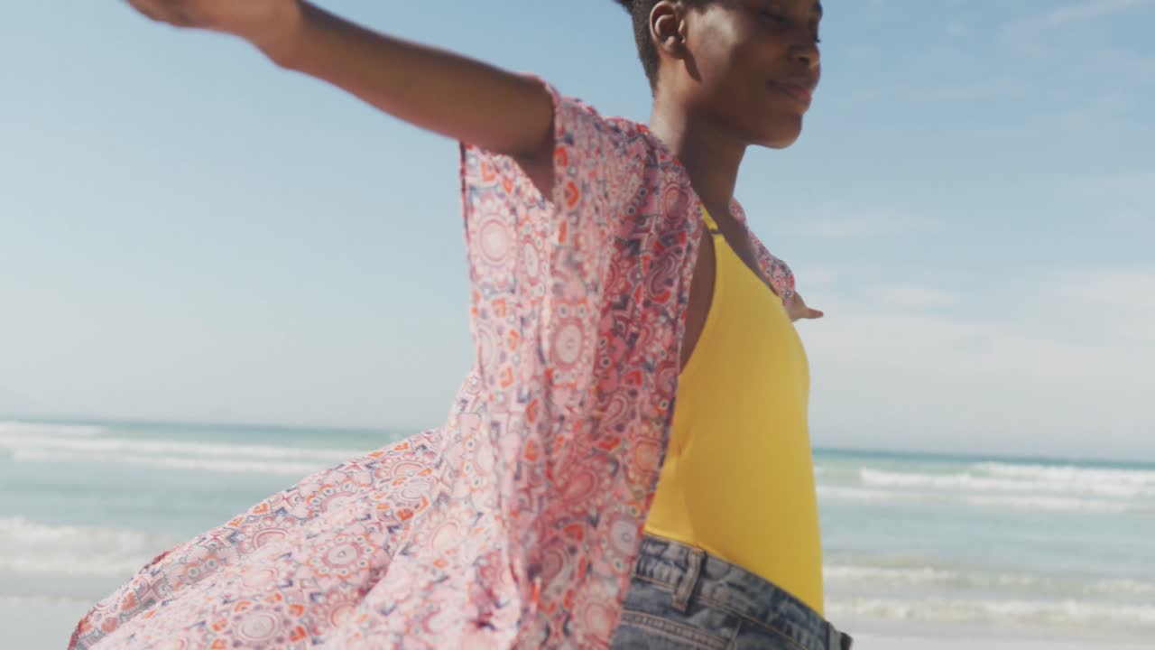 행복한 아프리카계 미국인 여성은  ⁇ 한 해변에서 팔을 넓히고 있습니다.