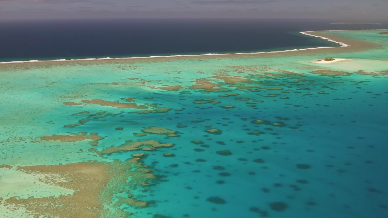 통가의 깊고 푸른 바닷물 가장자리에 있는 광대한 얕은 암초 시스템의 높은 공중 비행