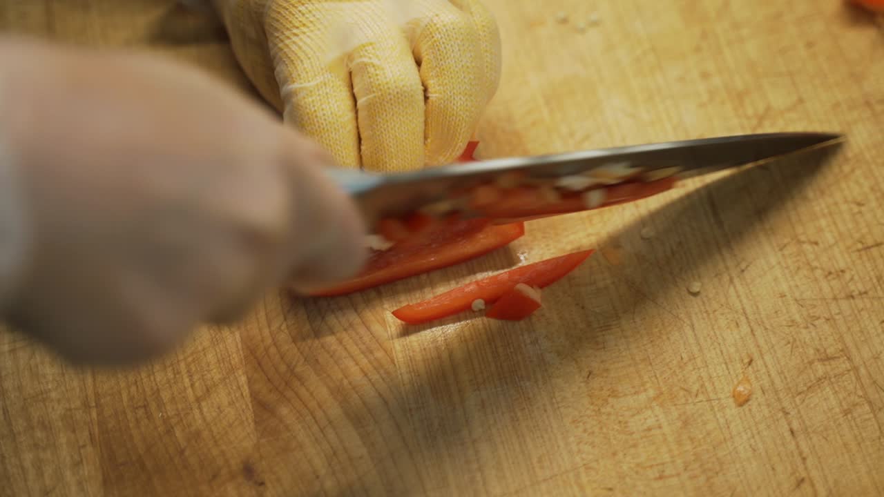 Thinly slicing and cubing a red chili pepper.