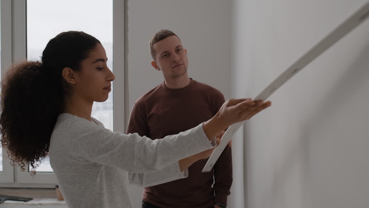 Couple Installing Wall Molding During Home Renovation