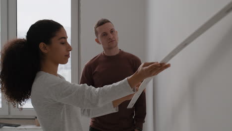 couple installing wall molding during home renovation