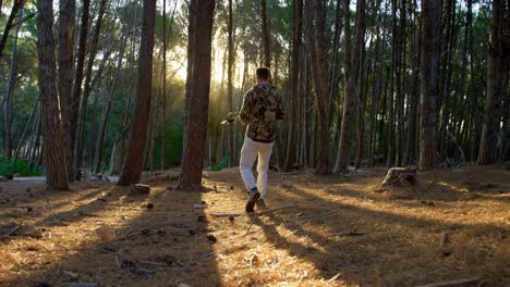 man walking with bow and arrow in the forest 4k