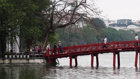 personas cruzando un puente rojo sobre el agua