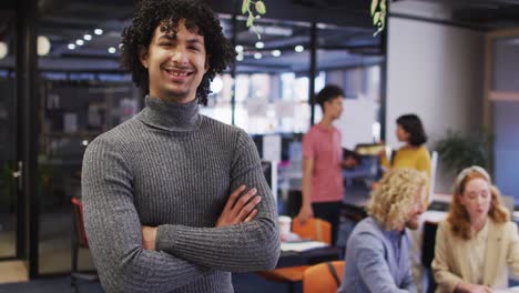 Portrait-of-happy-biracial-businessman-with-arms-crossed-at-office