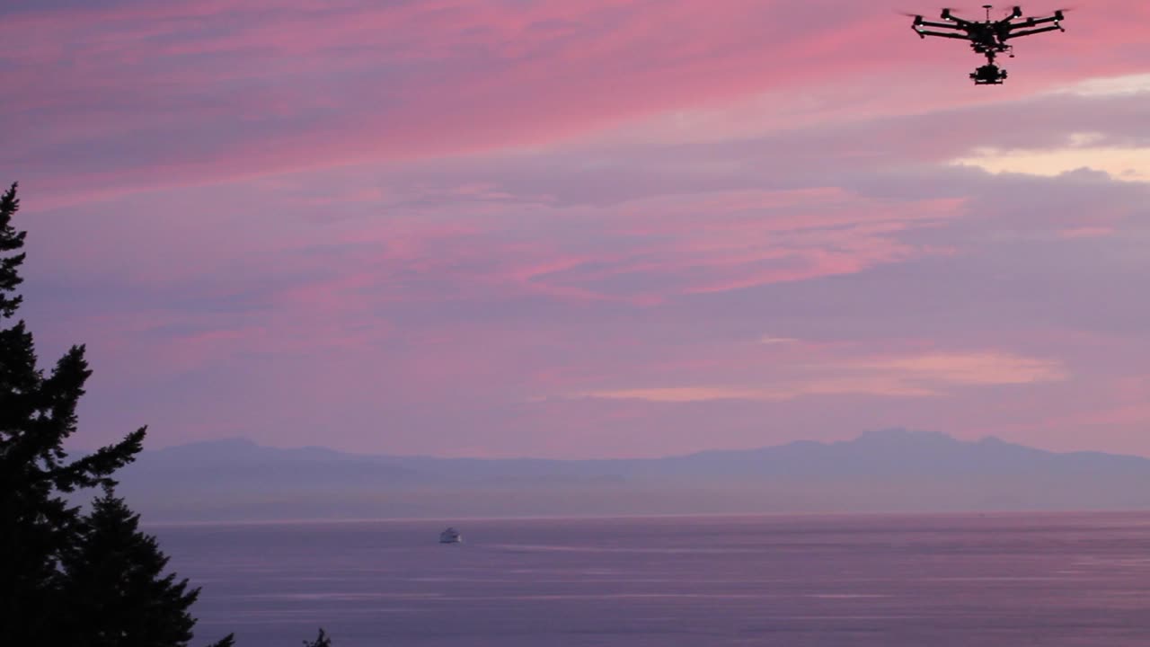 Mega drone DJI S900 che vola al tramonto con sfumature rosa e viola.