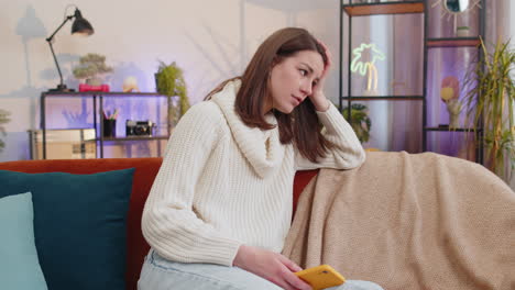 sad young woman use smartphone surprised by bad news, fortune loss, fail, lottery results, deadline