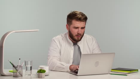 man looking at a laptop in an office setting