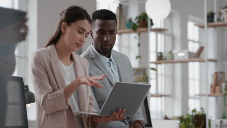 business meeting team leader woman brainstorming with businessman colleague using laptop computer showing ideas pointing at screen working together in office