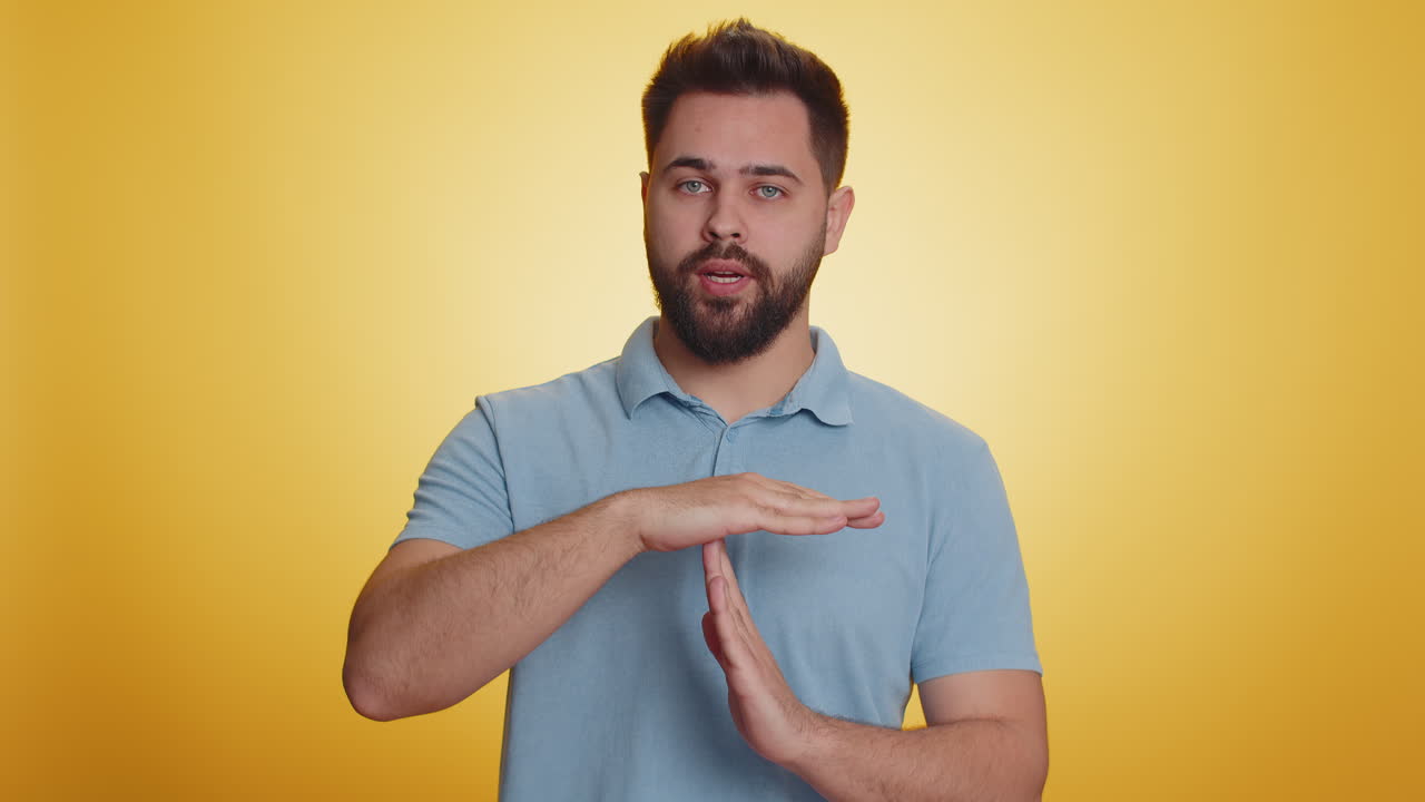 Tired serious upset caucasian man showing pause gesture stop sign time out relax break deadline