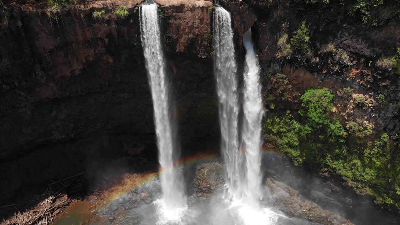 Aerial Crane Shot over Wailua Falls with Beautiful Rainbow Reflection on the Water.