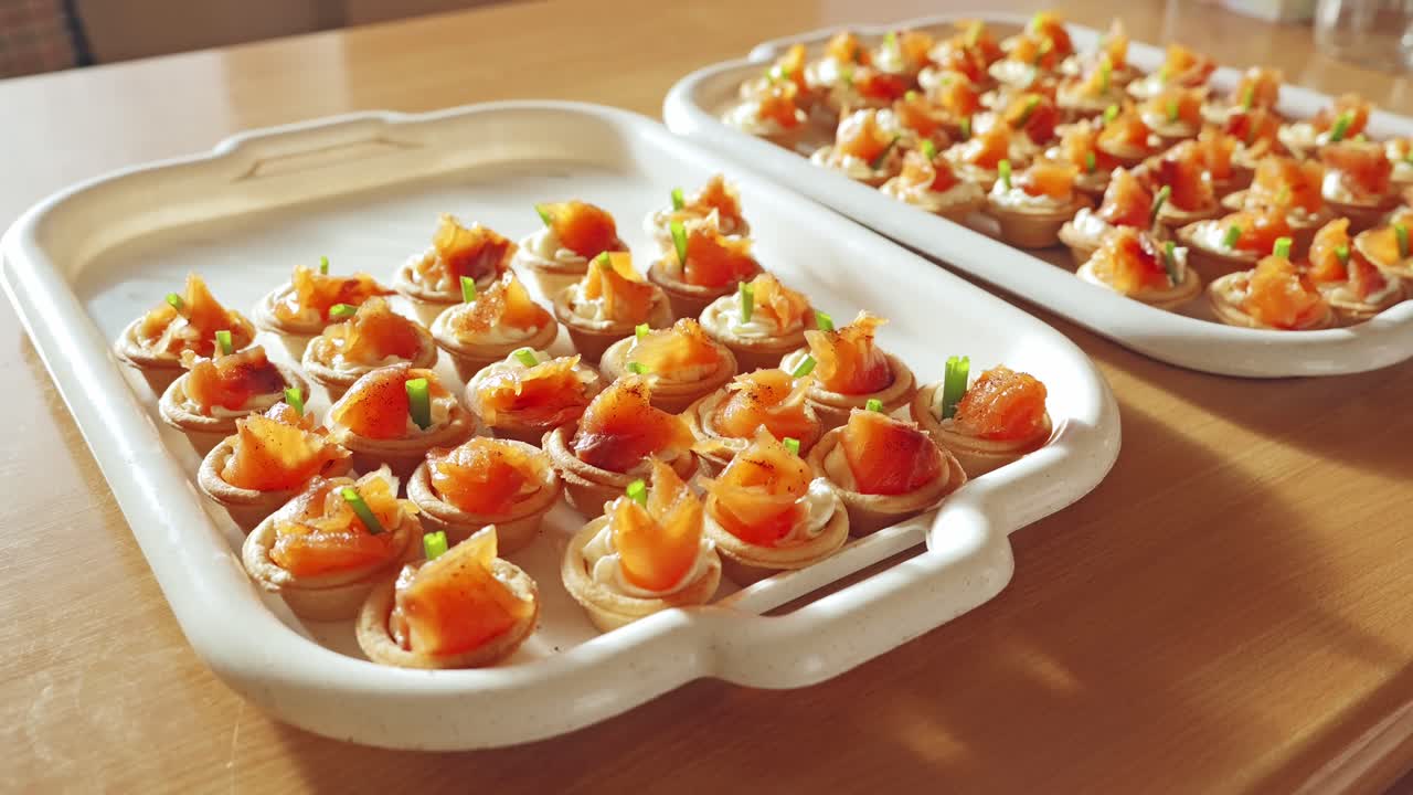Appétissantes tartelettes au saumon avec de la crème et des herbes soigneusement disposées avant la célébration