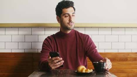 hombre usando el teléfono en un café
