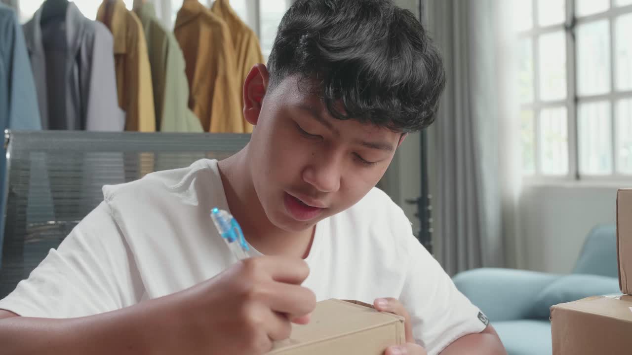 Teenager Writing on a Cardboard Box