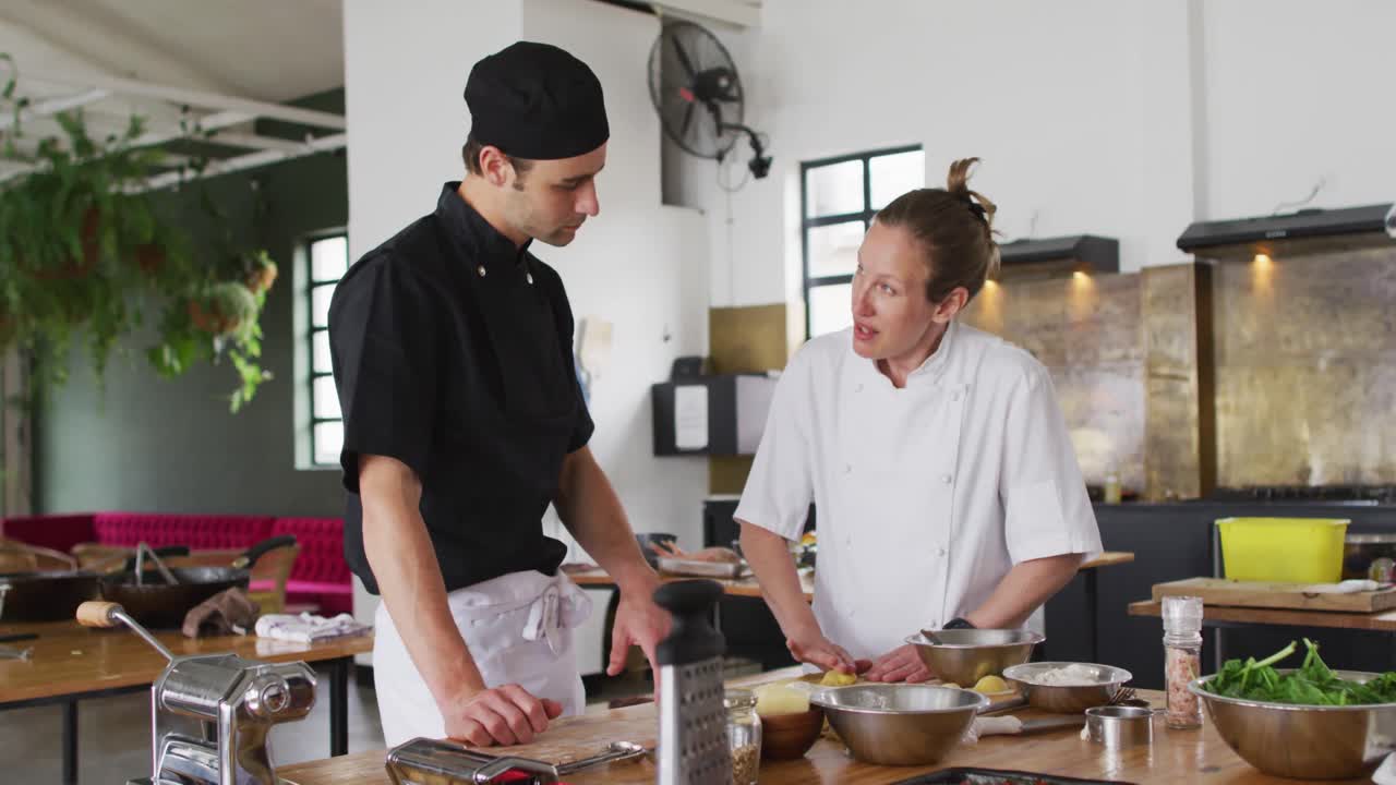 cocinera caucásica enseñando a un grupo diverso preparando platos y sonriendo