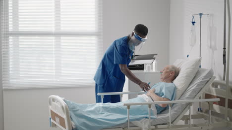 a black male surgeon is talking to an elderly male patient lying on a hospital bed. a female cardiologist infectious disease specialist is talking to a patient in the clinic