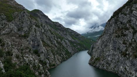 Serene aerial view of Lake Komani with steep mountains surrounding the water