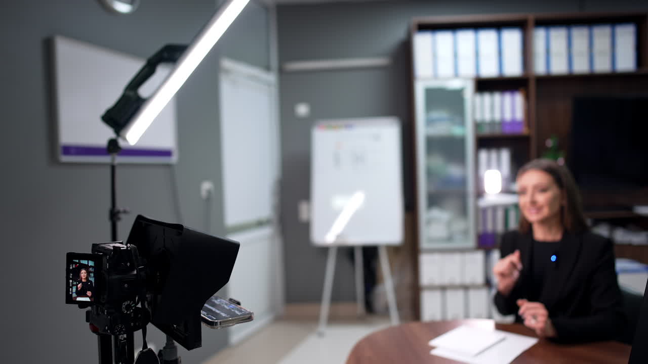 Caucasian female speaking distinctly and gesturing actively. Blurred image. Blog content creation.