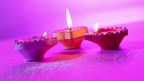 primer plano de las velas coloridas que queman celebrando diwali sobre un fondo púrpura