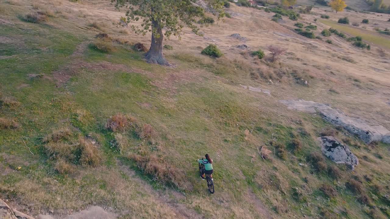 niña montando una bicicleta en la naturaleza tiro de drones