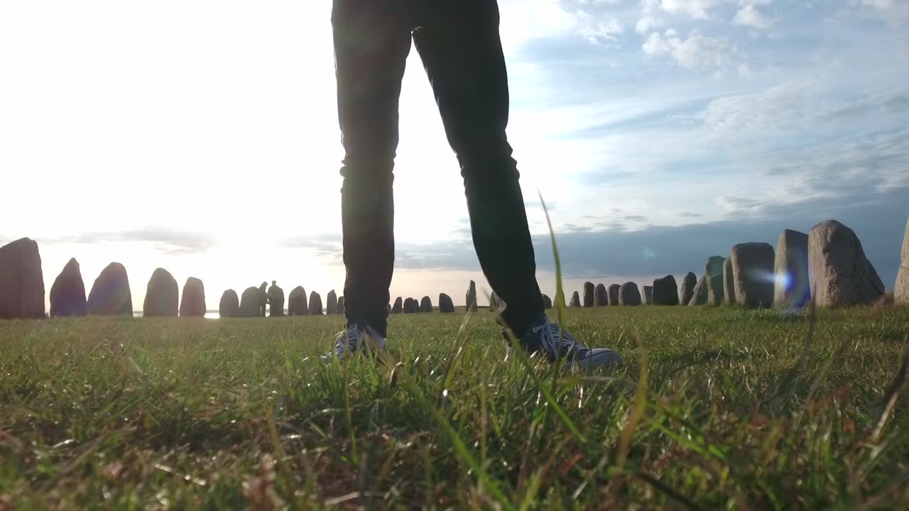 여름, 남쪽 스웨덴 skåne österlen kåseberga, 정적에 일몰에 ales stenar 앞에 서 검은 청바지와 컨버스와 남성 다리