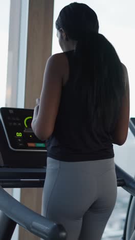 mujer haciendo ejercicio en una cinta de correr en el gimnasio
