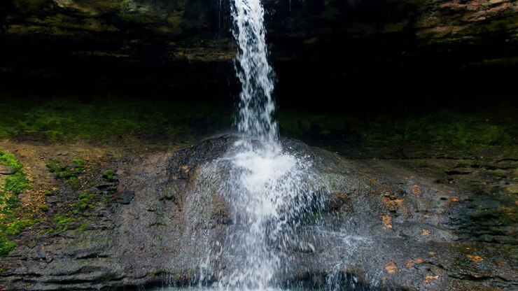 Drone view of cascade waterfall in Saharna Monastery, Moldova. Forest and cave. Slow motion