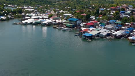 A-village-made-up-of-houses-on-stilts-along-a-beautiful-coastline-in-Surigao-City,-Philippines