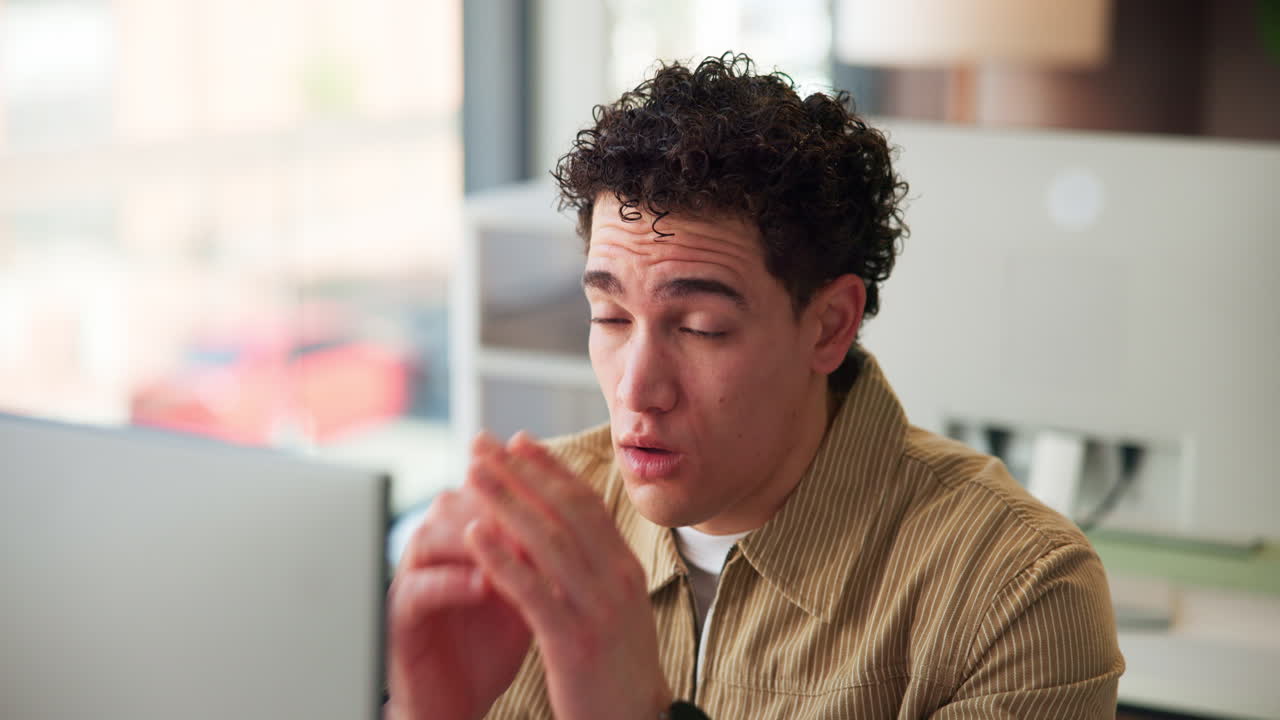 Tired Young Man Rubbing Eyes While Working on Laptop in Office